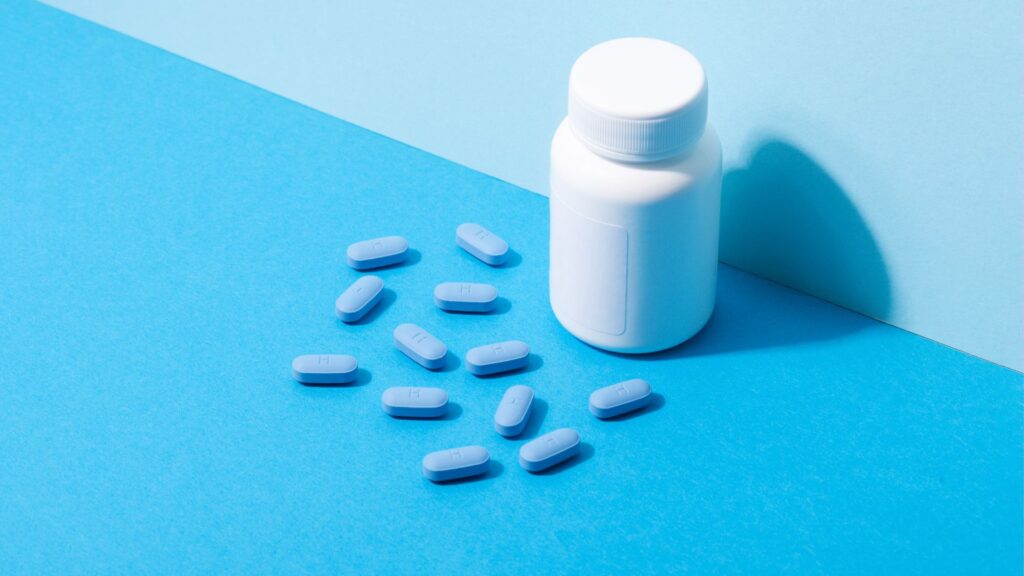 Blue pills and a medicine bottle